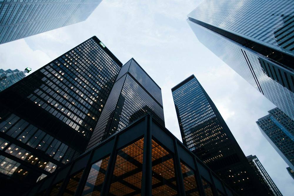 Commercial office towers viewed from street level, representing the commercial property and business lending Bestta Capital funds.